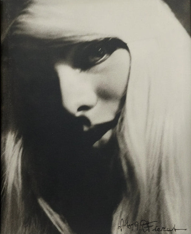 Black and white portrait of a woman with long hair, partially covering her face.